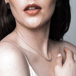 a stunning delicate silver necklace that features 10 small balls