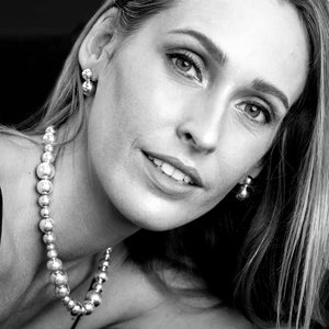 Black and white portrait of a woman wearing statement ball necklace