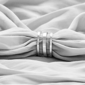 Sophie Anna ring stack featuring two Stack Ring D's and a central Stack Ring C, minimal style bands, elegantly displayed on soft fabric background.