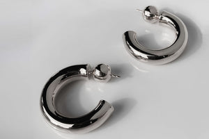 Close-up view of elegant sterling silver tube hoop earrings displayed against a minimalist background, perfect for sophisticated everyday wear - Sophie Anna Collection.