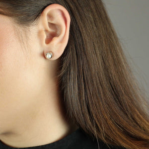 Pearl stud earrings on model
