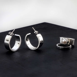 A contemporary jewellery combination of large sterling silver hoops and stack rings that feature a freshwater pearl.