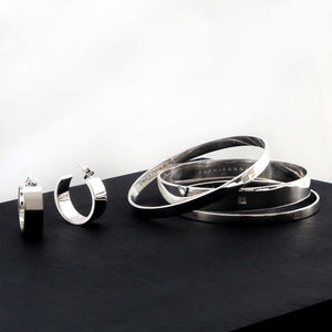 a contemporary jewellery set of sterling silver bangles and wide hoop earrings